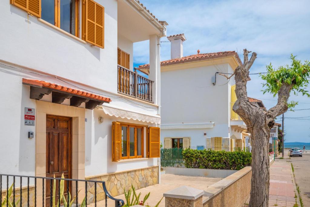a white house with a tree in front of it at Ca Na Clara - Villa Pascual in Port de Pollensa