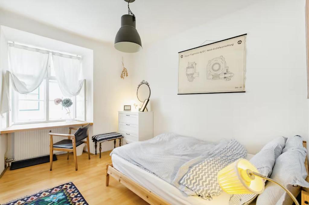 a bedroom with a bed and a desk and a window at Altstadtzimmer im Herzen des historischen Wiens in Vienna
