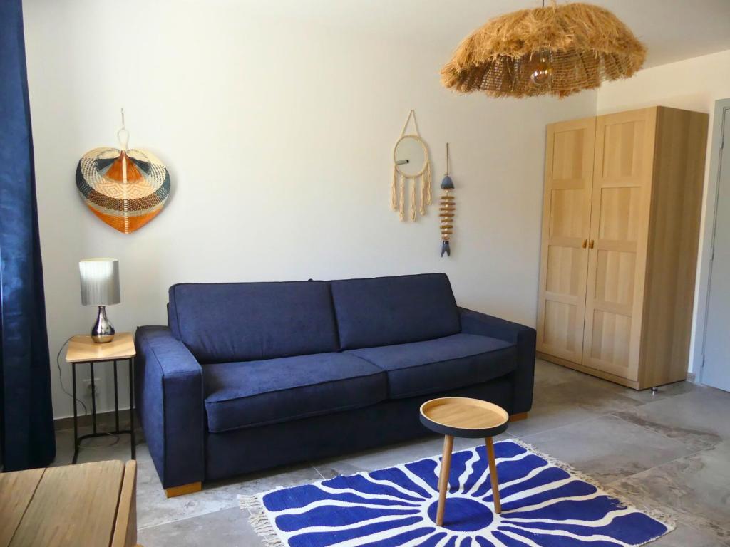 un salon avec un canapé bleu et une table dans l'établissement L'appart Cassis, à Cassis