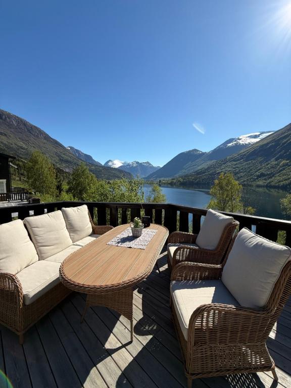 a patio with a table and chairs and a view of a lake at Tenden Panorama in Stryn