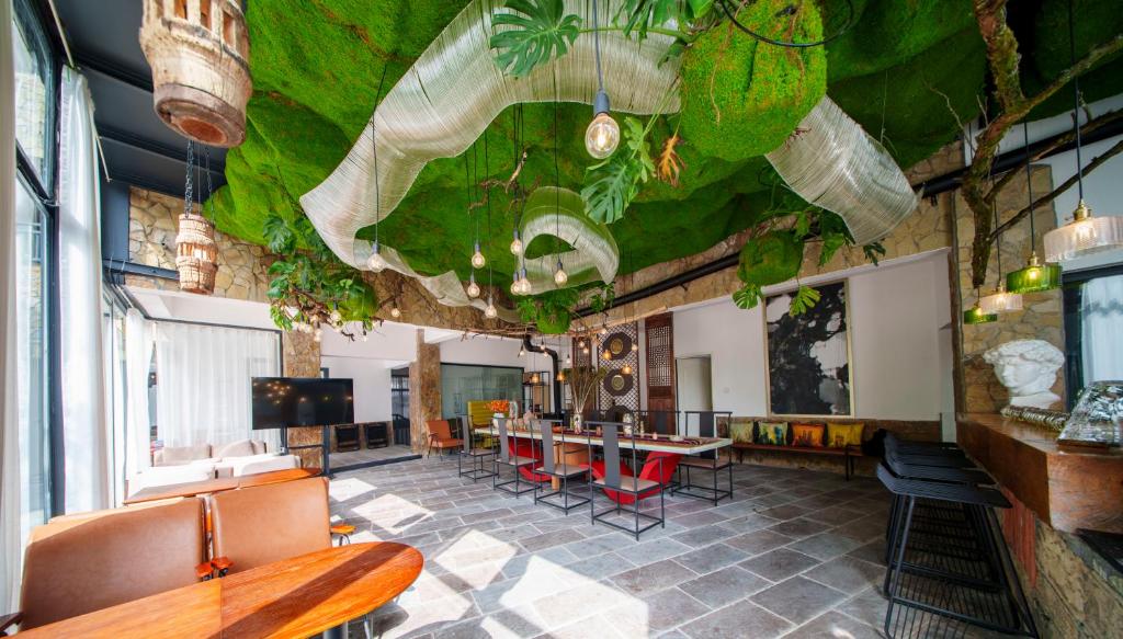 a room with a table and chairs and a room with plants at Tianmen Mountain Panorama & Cultural Art Exchange Hostel in Zhangjiajie
