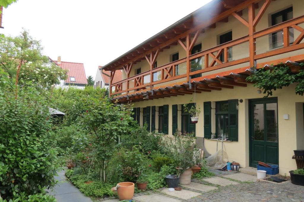 a building with trees and plants in front of it at Ferienwohnung 2 am Zwenkauer See-frisch renoviert in Zwenkau