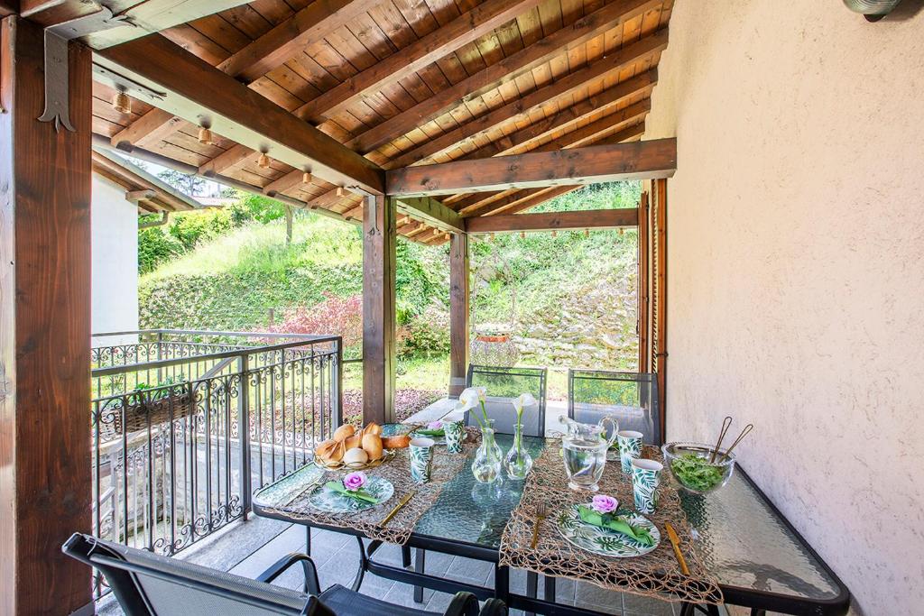 a balcony with a glass table and chairs at L’Acero Rosso - Giardino privato e Box auto in Menaggio