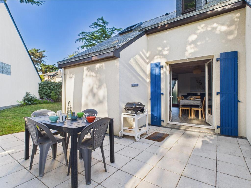 a patio with a table and chairs and a grill at 400m de la plage, jardin, maison pour 5 in Kermoisan