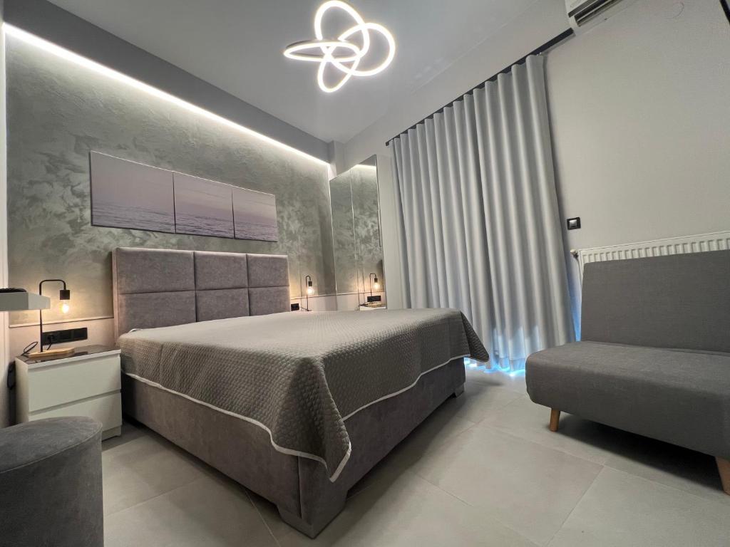 a bedroom with a large bed and a chair at Selena Boutique in Neos Marmaras