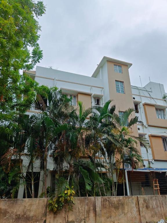 a building with palm trees in front of it at Sidds Hospitality Inn in kolkata