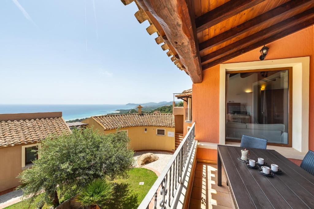 a patio with a table and chairs on a balcony at Cliffside Blue in Costa Rei