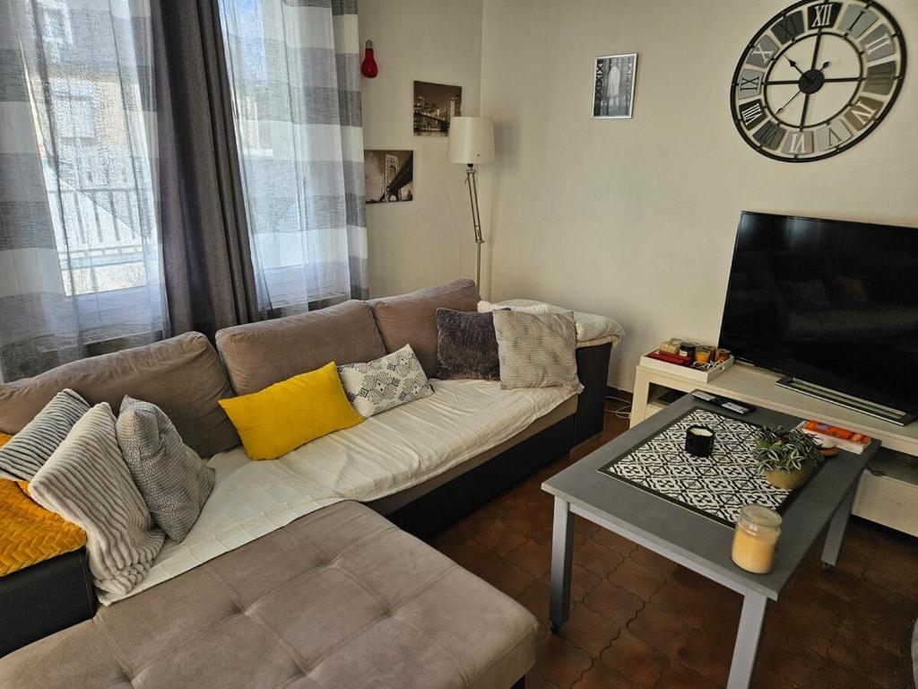 un salon avec un canapé et une télévision dans l'établissement House 10 minutes' walk to 24h, à La Celle-sous-Gouzon
