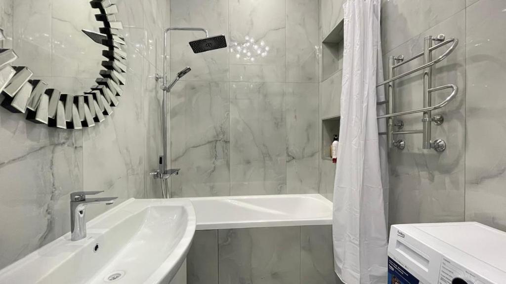 a white bathroom with a sink and a shower at ЖК Madina in Petropavlovsk