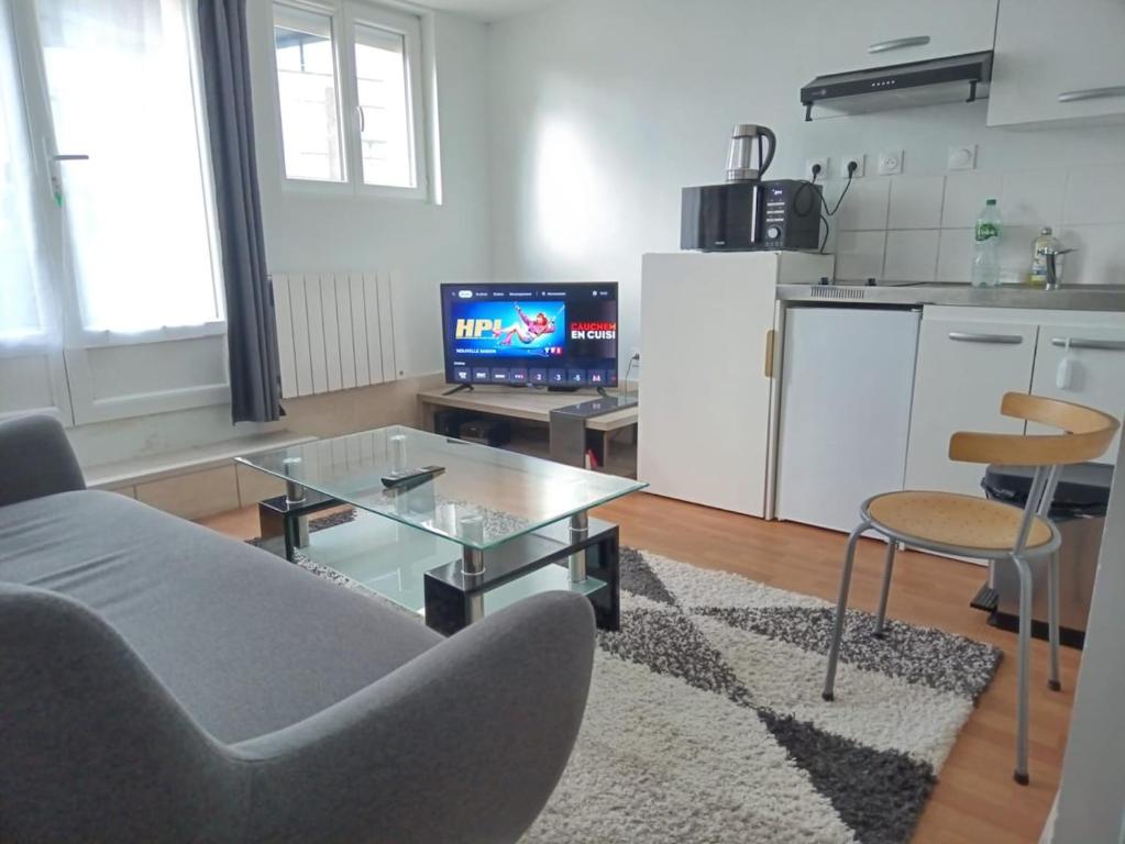 un salon avec un canapé, une table et une télévision dans l'établissement Apparemment 2 pièces privé pour vous, à Mantes-la-Ville
