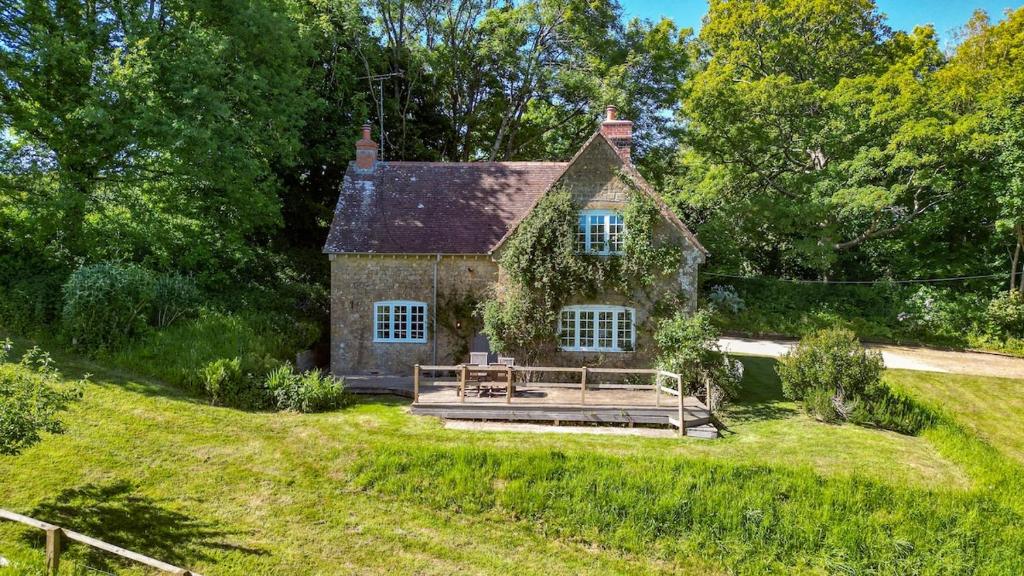 an old house on a hill with a wooden deck at Luxury 2 Bed Woodland Cottage on Rewilding Estate in Beaminster
