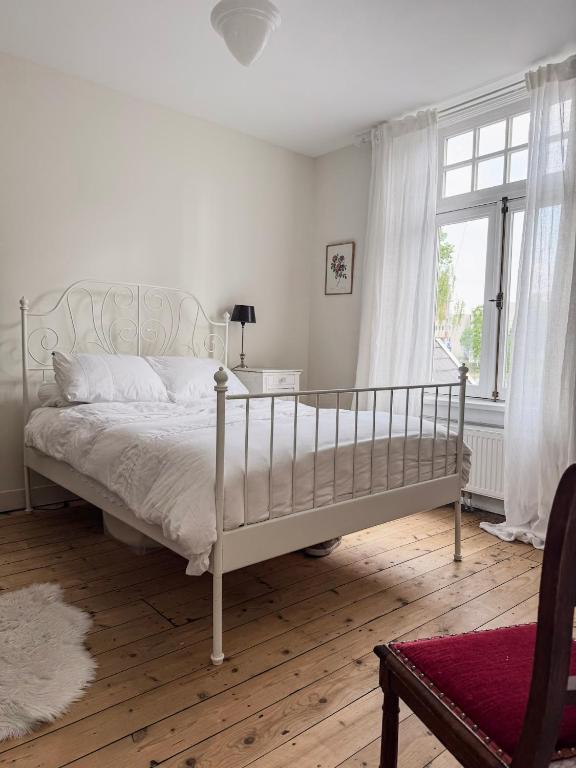 a bedroom with a white bed and a window at Romantische kamer nabij centrum in Eindhoven