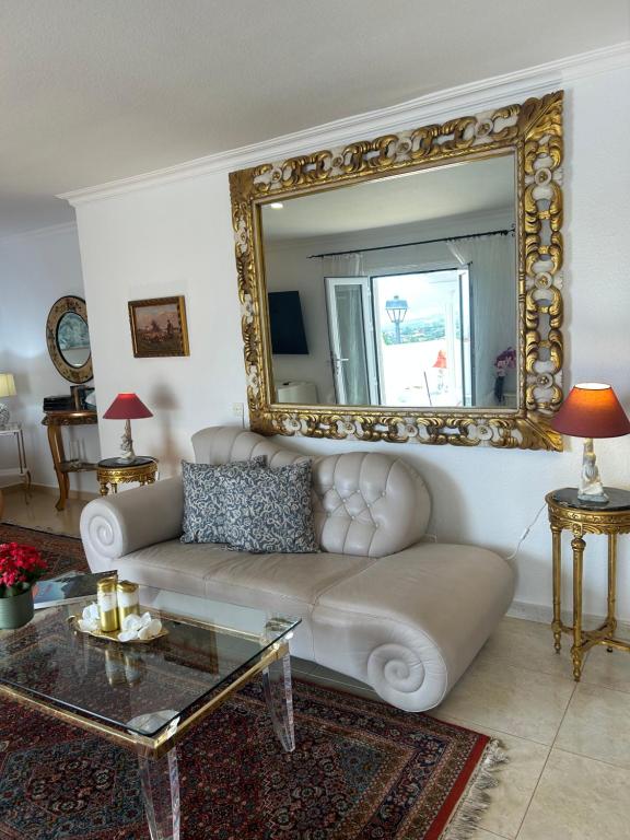 a living room with a couch and a mirror at Schönes Apartment - ruhig - Aussenpool in La Orotava
