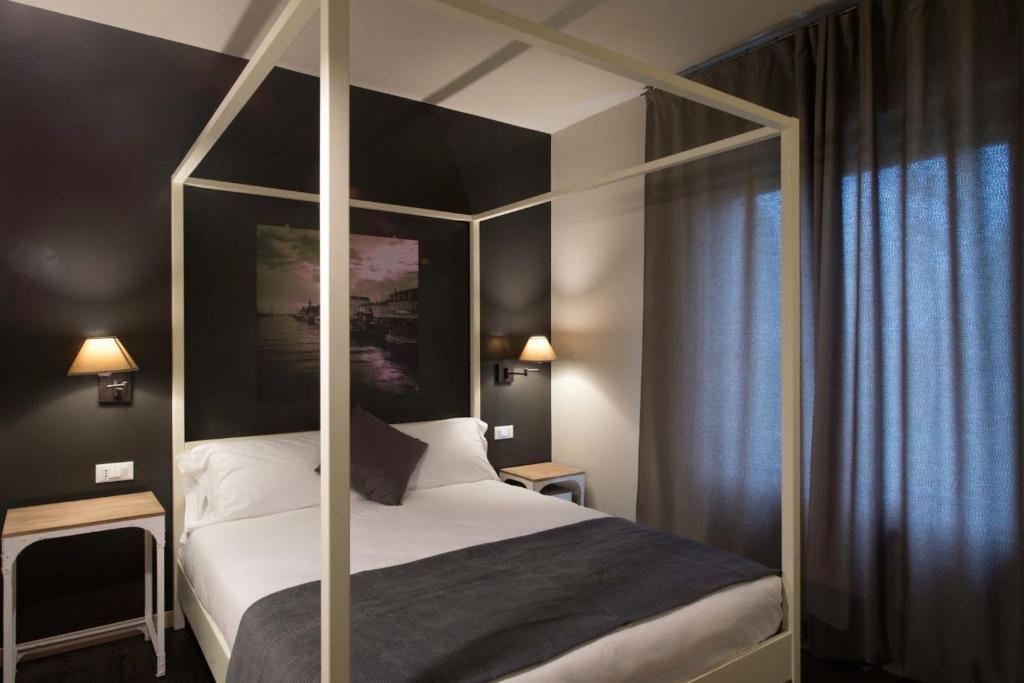 a bedroom with a four poster bed with a canopy at Hotel B&B il Mosaico in Sirmione