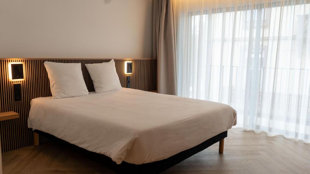 Postel nebo postele na pokoji v ubytování Brit Hotel Grand Hotel Munster