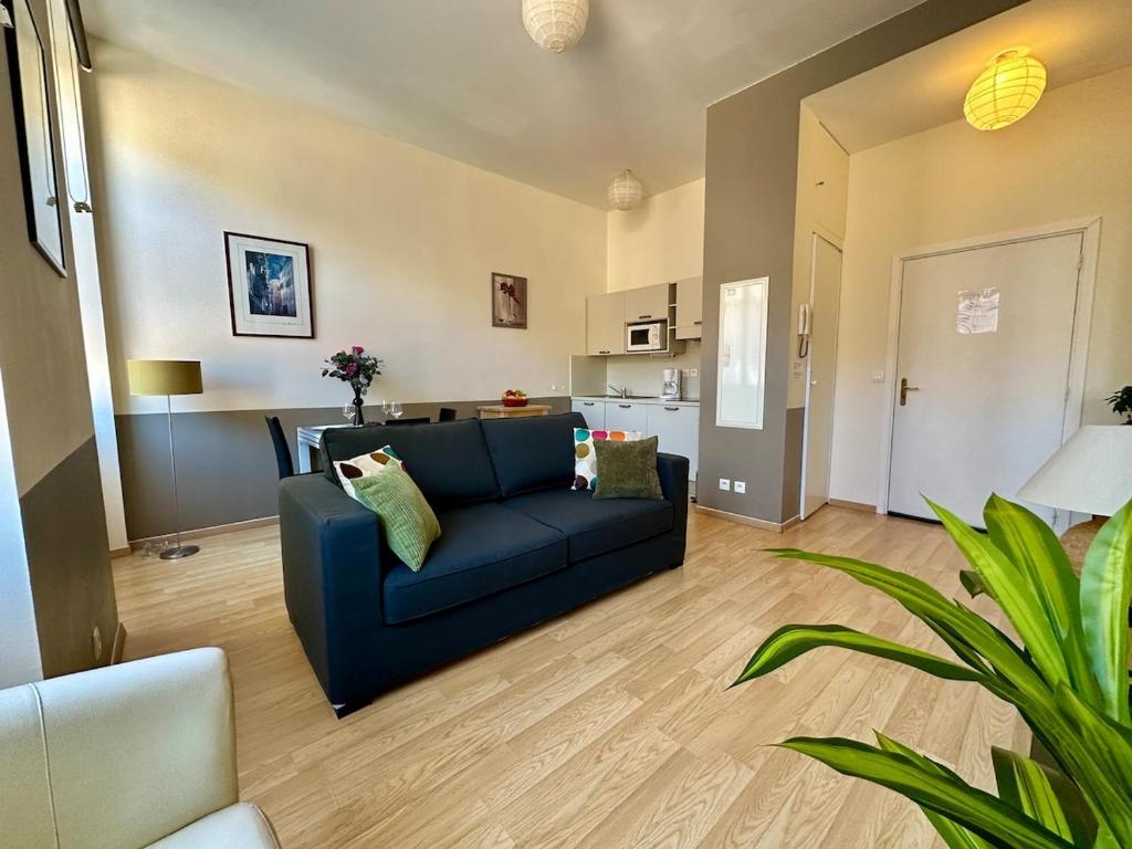 un salon avec un canapé bleu et une cuisine dans l'établissement Magnifique 2 pièces - Hyper centre Nice, à Nice