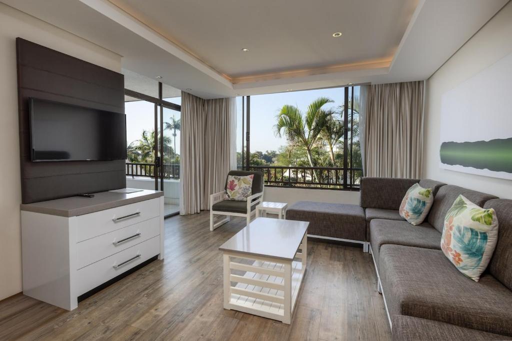 a living room with a couch and a flat screen tv at The Breakers 310 in Durban
