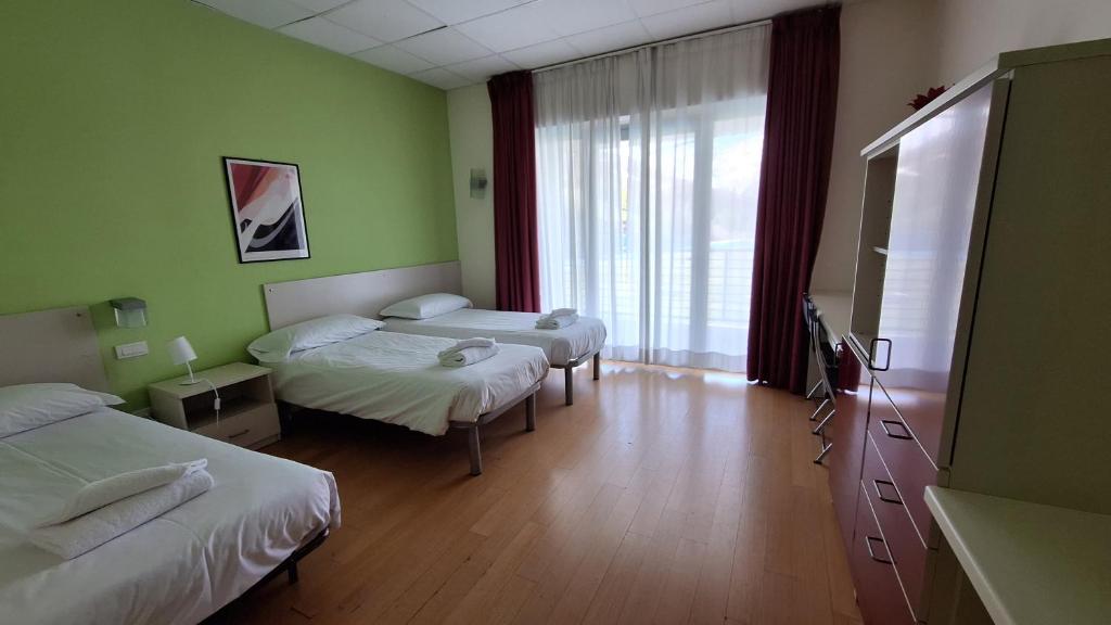 a hotel room with two beds and a window at Hotel Lago Losetta in Sestriere