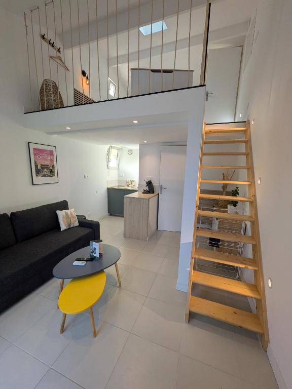 un salon avec un canapé et une table dans l'établissement Cyprès des cigales - Duplex meublé de tourisme, à Saint-Georges-dʼOrques