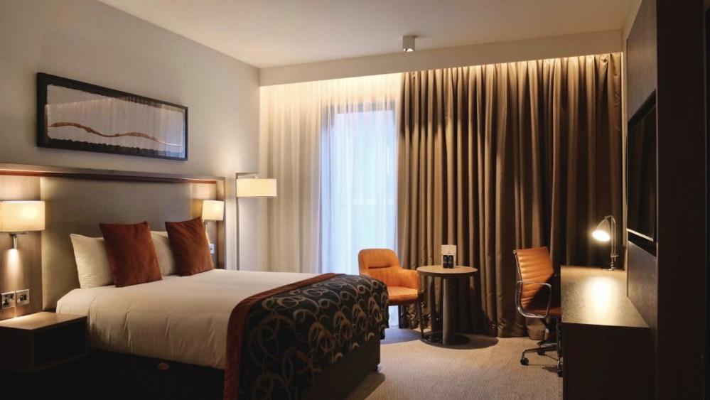 バーミンガムにあるClayton Hotel Birminghamのベッドと椅子付きのホテルルーム