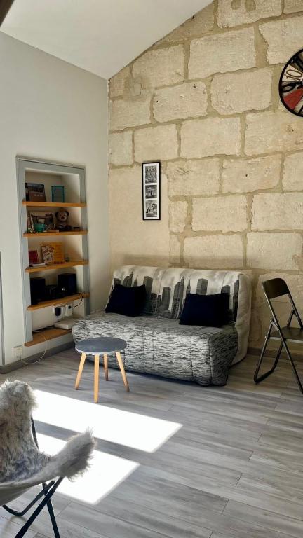 un salon avec un canapé et un mur de briques dans l'établissement Loft Bohème Placette, à Nîmes