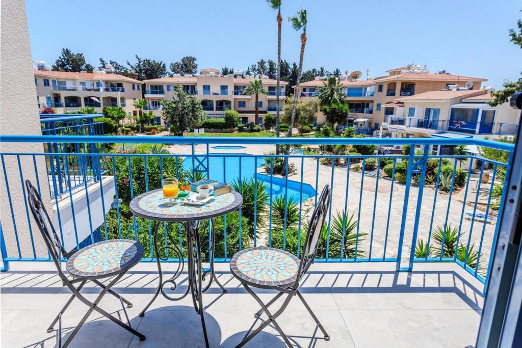 a balcony with a table and chairs and a pool at All Seasons Boutique Townhouse in Paphos City