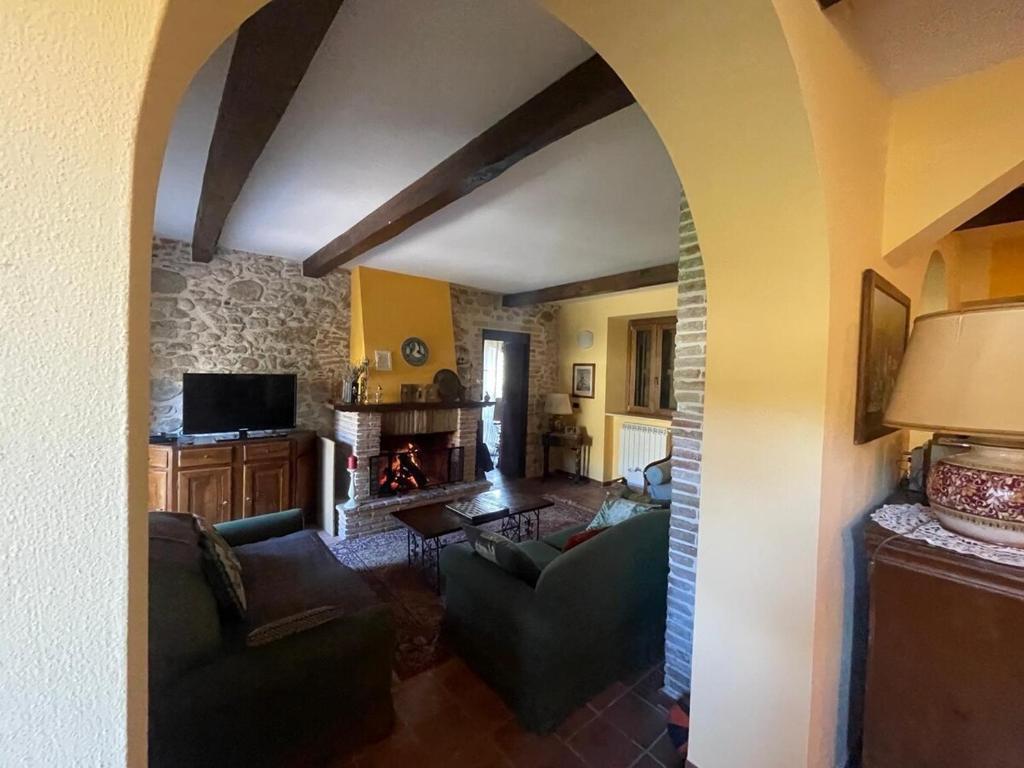 a living room with a couch and a fireplace at Il Mulino esclusivo soggiorno in Colle