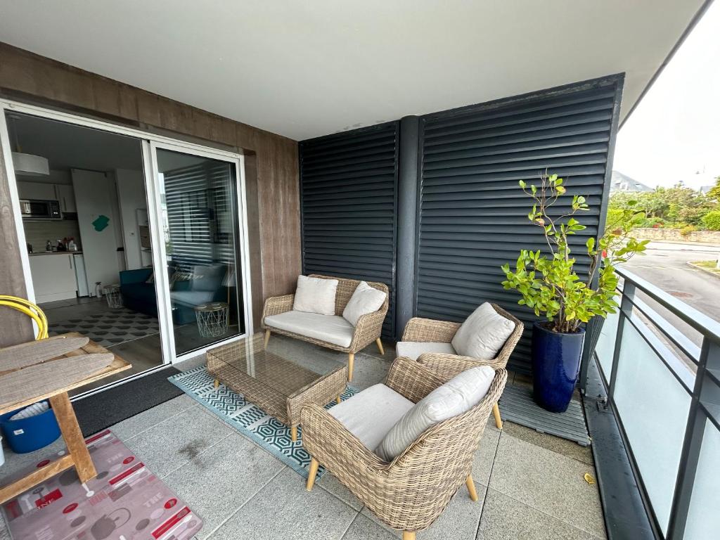 a patio with two chairs and a table on a balcony at Appartement port du Crouesty avec terrasse et piscine in Arzon