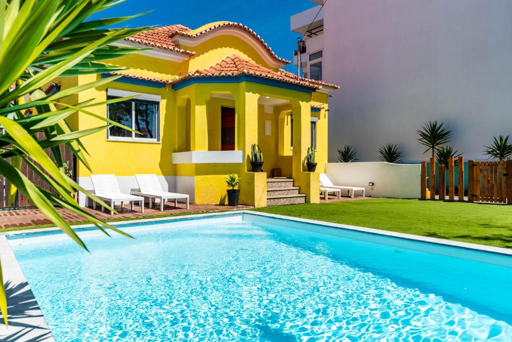 a villa with a pool in front of a house at Kali Vice Surf Villa in Costa da Caparica