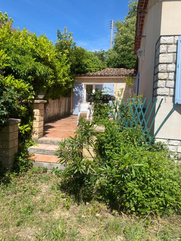 un jardin avec un banc et une maison dans l'établissement Chambre, terrasse , salle de bains toilettes privé, à Valensole