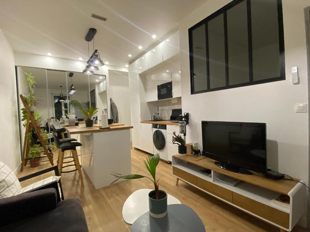 un salon avec une télévision à écran plat sur une table dans l'établissement Palais de l esplanade, à Nice