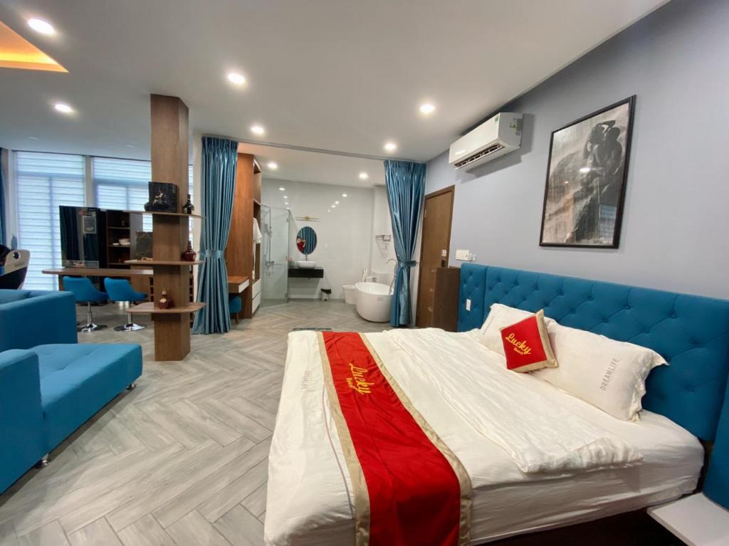 ホーチミン・シティにあるLucky hotelのベッドルーム(青いベッド1台付)、バスルーム