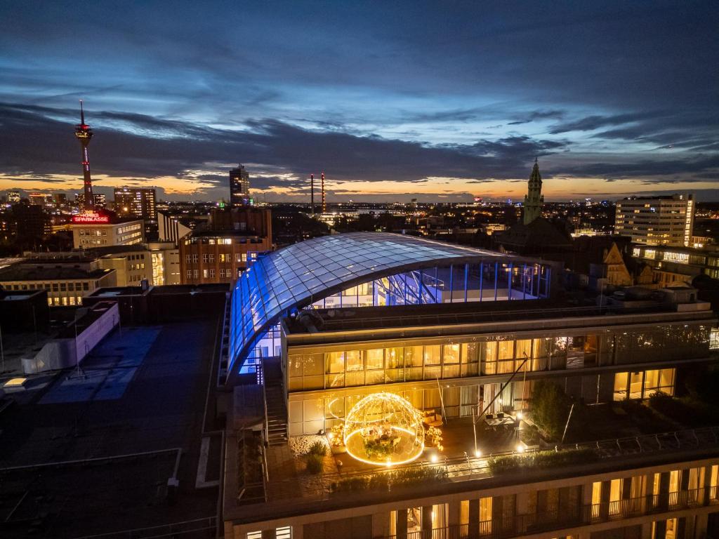a building with a clock on the side of it at night at Hotel Kö59 Düsseldorf - Member of Hommage Luxury Hotels Collection in Düsseldorf