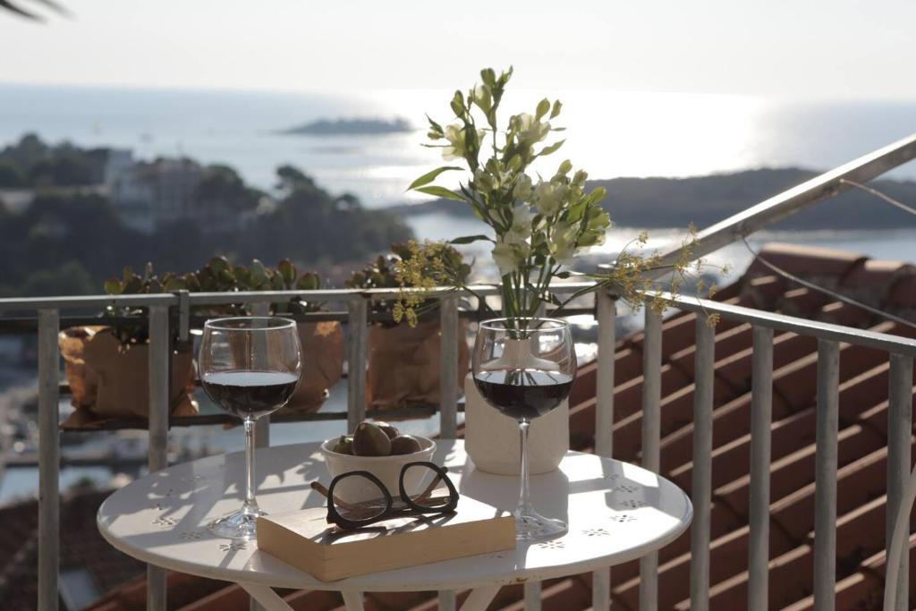 a table with two glasses of wine on a balcony at Casa Degrassi - Main square - Seaview in Vrsar