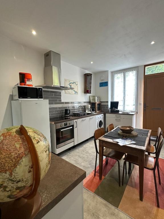 une cuisine avec une table et une salle à manger dans l'établissement Maison Années 30 - Terrasse - Parking gratuit - Proche CV, à Quimper