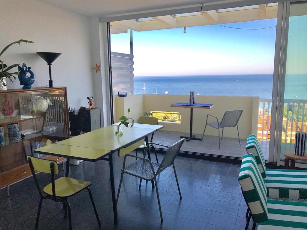 a dining room with a table and chairs and a view of the ocean at Cosy apartment with fabulous SEA VIEWS 70's style in Sant Feliu de Guixols