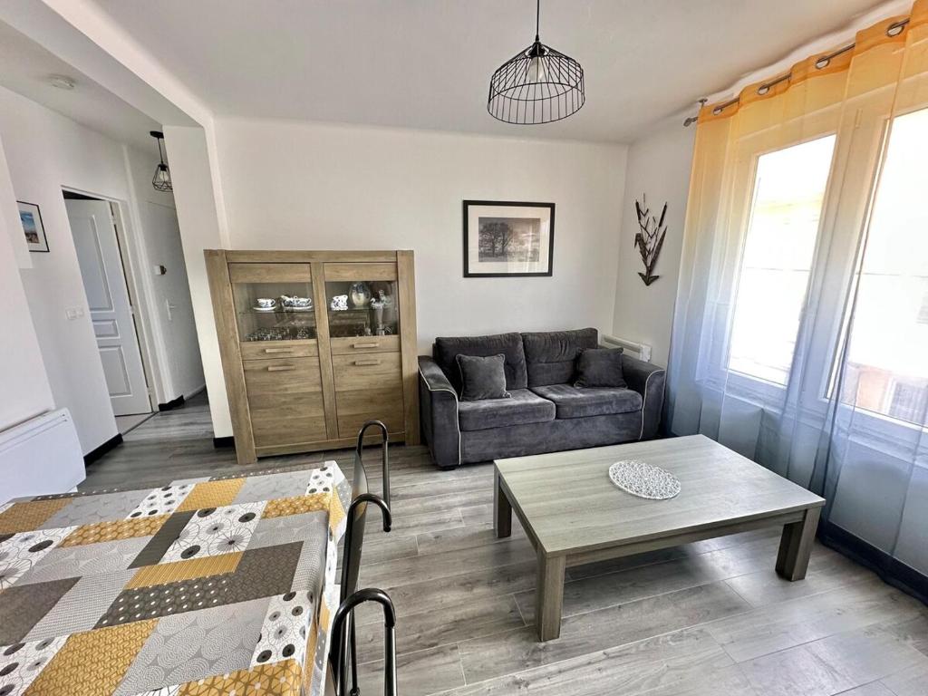 un salon avec un canapé et une table dans l'établissement Appartement à deux pas de la plage - 1 chambre, à Berck-sur-Mer