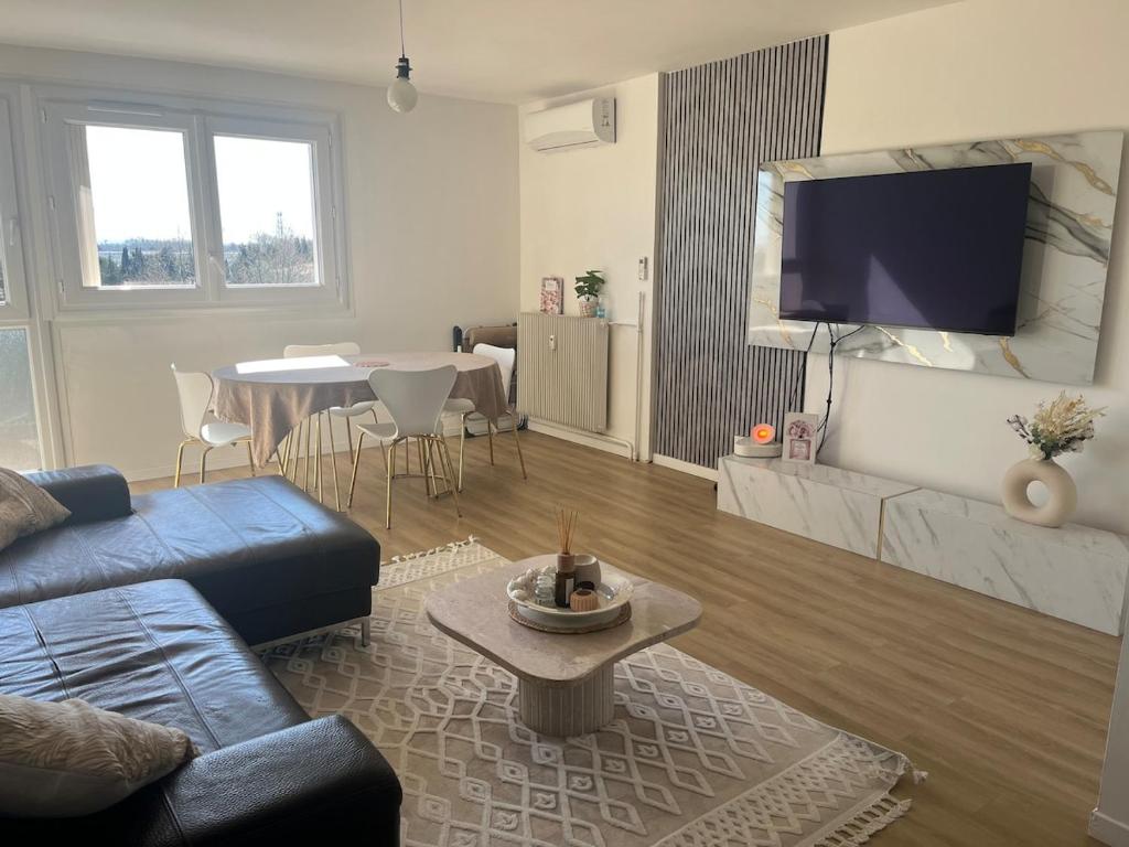 un salon avec un canapé bleu et une table dans l'établissement Appartement festival avignon, à Avignon