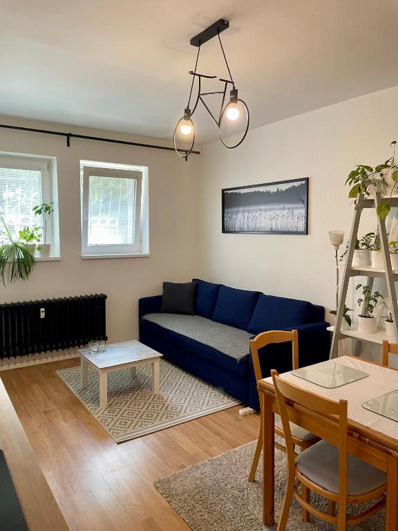 a living room with a blue couch and a table at Cozy Self check-in Apartment in vibrant Ruzinov area, Komárnická 42, Bratislava in Bratislava