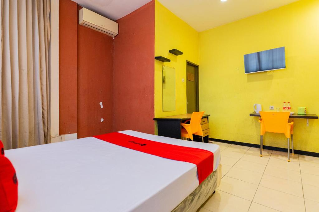 sypialnia z łóżkiem, stołem i krzesłami w obiekcie RedDoorz at Sparkling Hotel Surabaya w mieście Surabaja