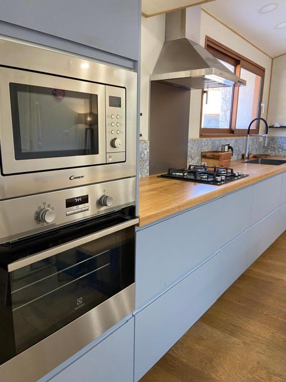 une cuisine avec une cuisinière et un micro-ondes dans l'établissement T2 bala, à Porto-Vecchio