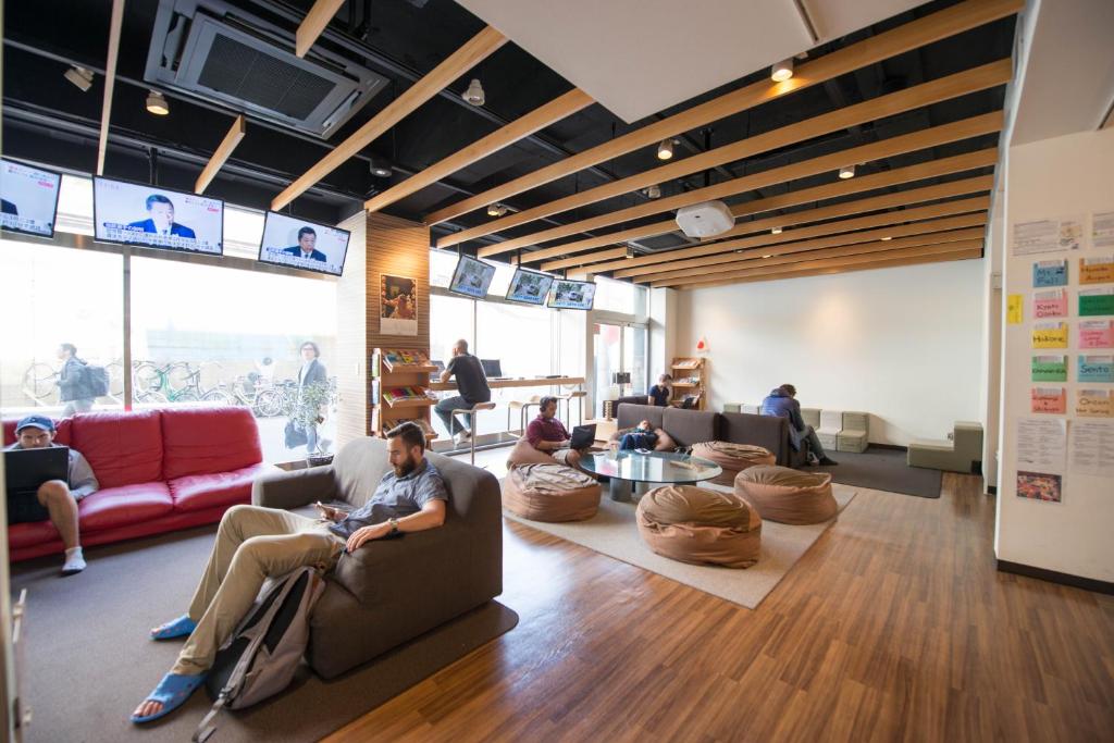 a group of people sitting in a living room at Anne Hostel Yokozuna in Tokyo