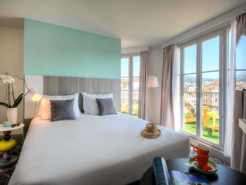 a bedroom with a large bed with a large window at Ibis Styles Nice Centre Gare in Nice