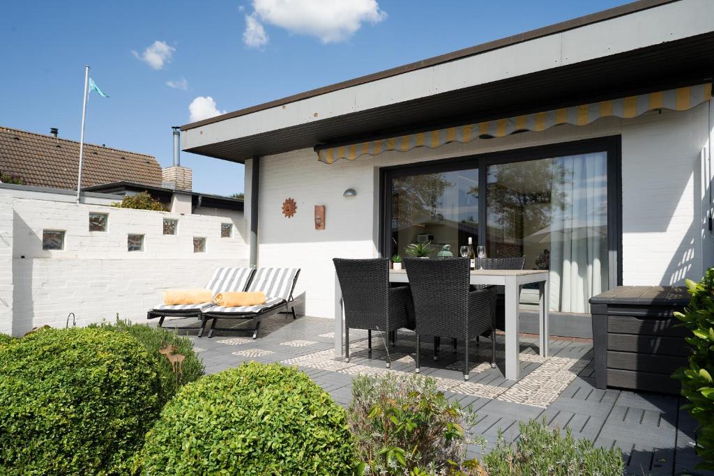 a patio with a table and chairs next to a building at Ferienhaus Brasch in Grömitz