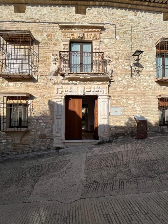 ein Backsteingebäude mit einer Tür und einem Balkon in der Unterkunft Casa con jardín y piscina en Córdoba in Córdoba