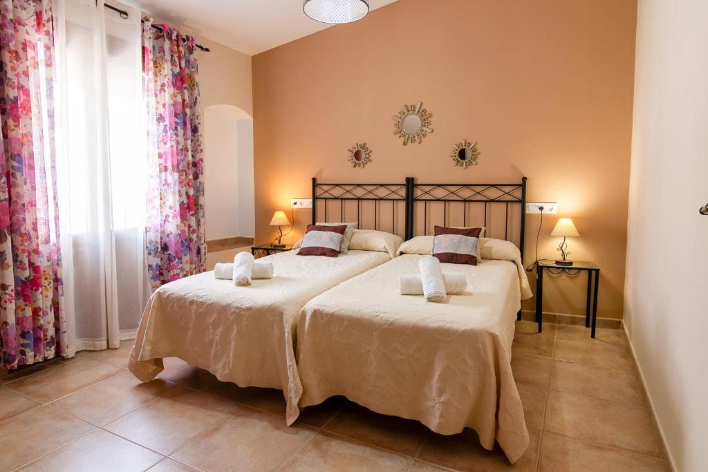 ein Schlafzimmer mit zwei Betten und einem großen Fenster in der Unterkunft Apartamentos Rurales Tía María in Mata de Alcántara