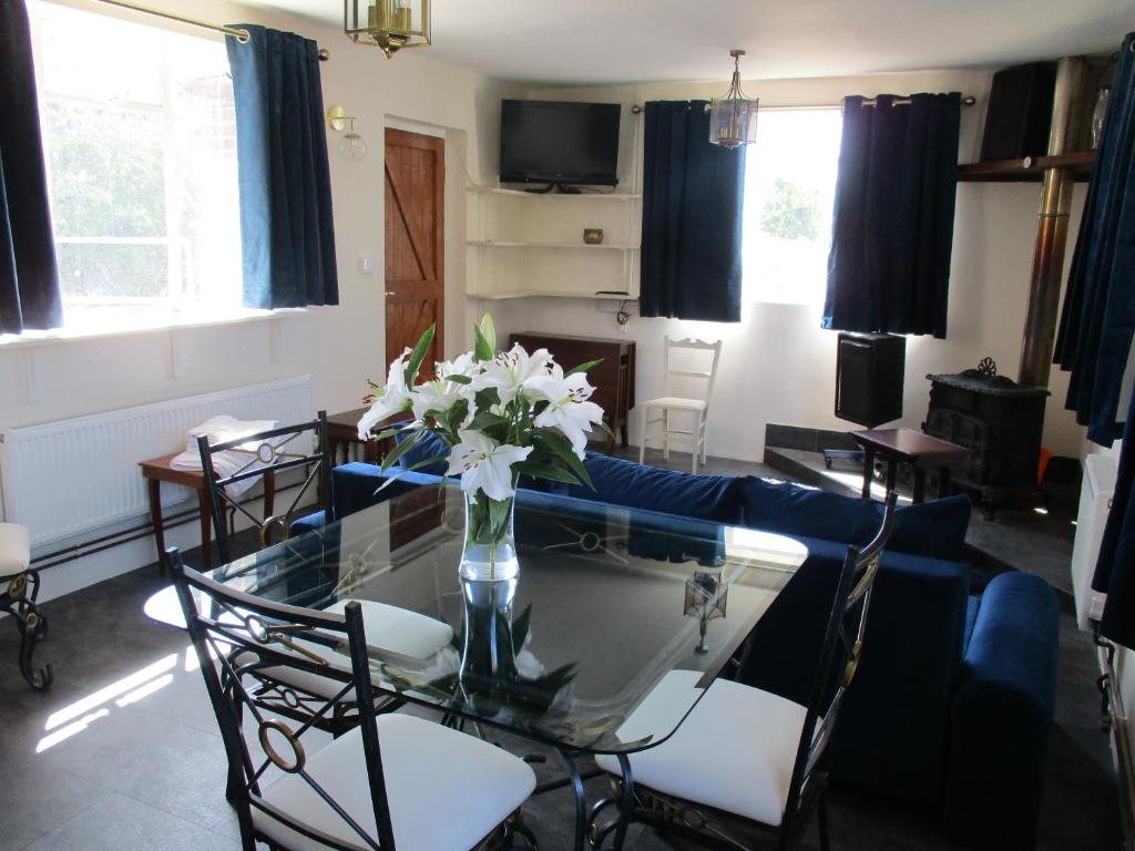 a living room with a glass table with flowers on it at Riverside Lodge At Bridge Stores in Great Yarmouth
