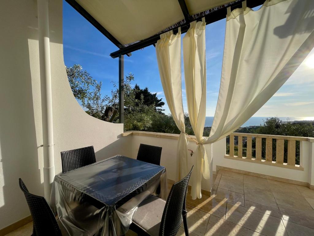 a balcony with a table and chairs and a window at CASA MELODIA - immersa negli uliveti con vista sul mare Ionio in Marina San Gregorio