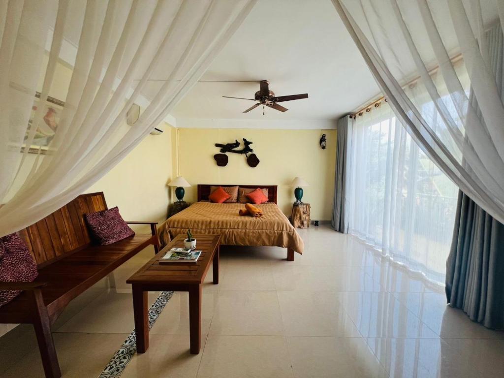 a bedroom with a bed and a large window at Homestay Yellow Natural House in Siem Reap