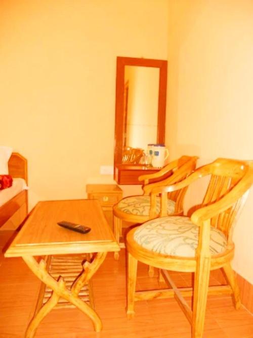 a room with two chairs and a table and a mirror at Guptkashi Palace in Gupta Kāshi
